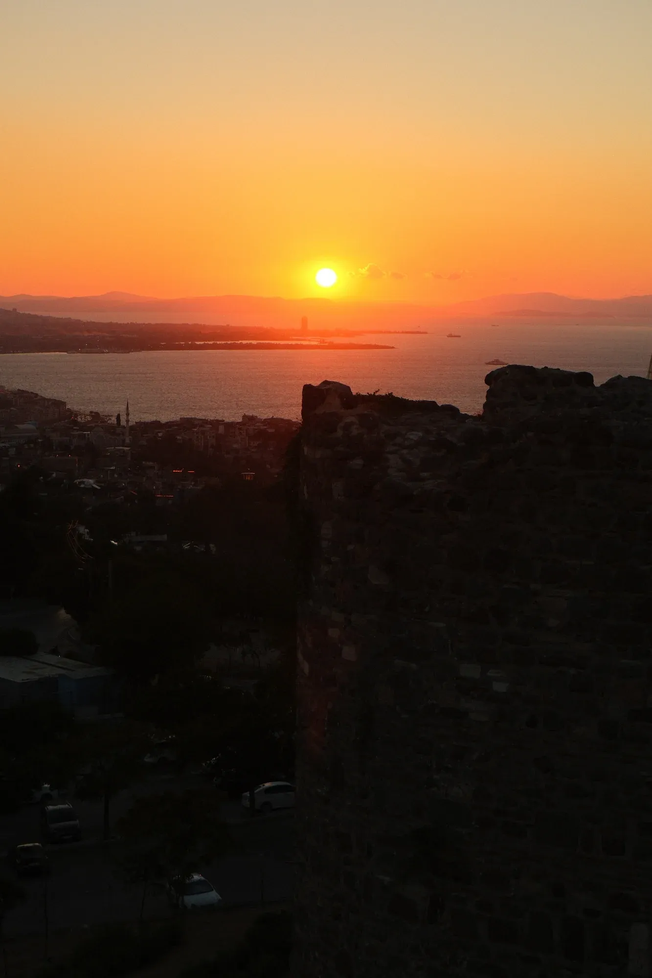 The sun setting over Izmir Bay behind the fortress walls