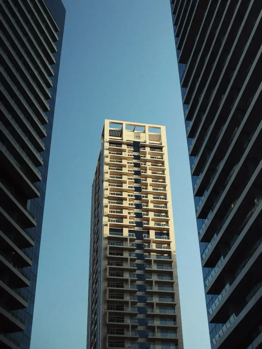 Looking up between towers at a sunlit high-rise. Photo by Kiran Johns